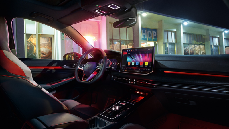 Interior view of a VW Golf GTI with ambient lighting activated.