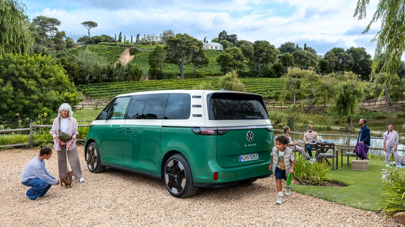 Eine Familie rastet mit ihrem VW ID. Buzz, welcher an einem See parkt.