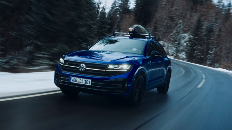 Un Volkswagen Touareg eHybrid de color azul oscuro circulando por una carretera