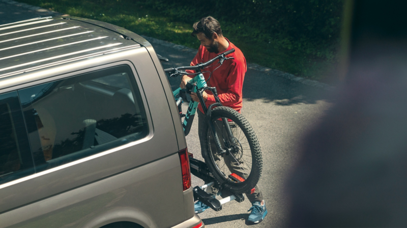 Mann hängt sein Fahrrad am Fahrradträger auf